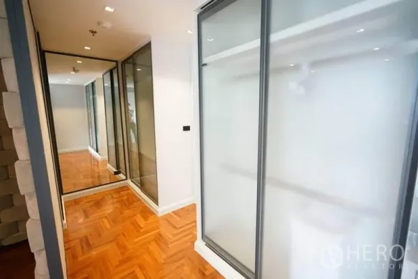 คอนโด ให้เช่าหรือขายในBang Na, Bangkok - โถงทางเดินสว่างพร้อมตู้บานเลื่อนกระจกฝ้า บานกระจกเงา และพื้นปาเกต์ลายก้างปลา