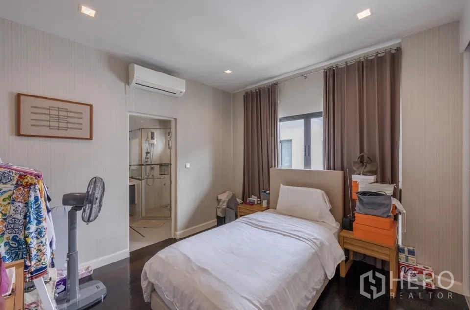 Detached House for rent or sale in Bang Kapi, Bangkok - Bedroom with air-conditioner and ensuite bathroom entrance.