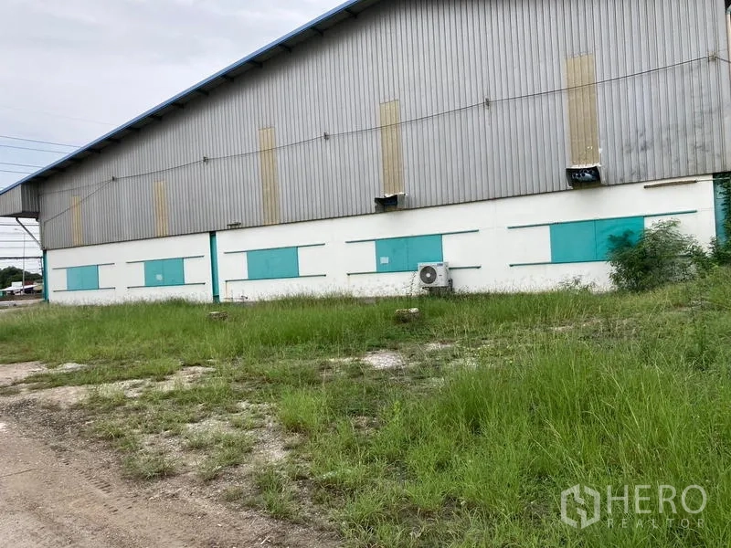 คลังสินค้า ให้เช่าในMueang Samut Sakhon, Samut Sakhon - ผนังด้านหลังโกดังมีช่องระบายอากาศ และพื้นที่หญ้าด้านนอก