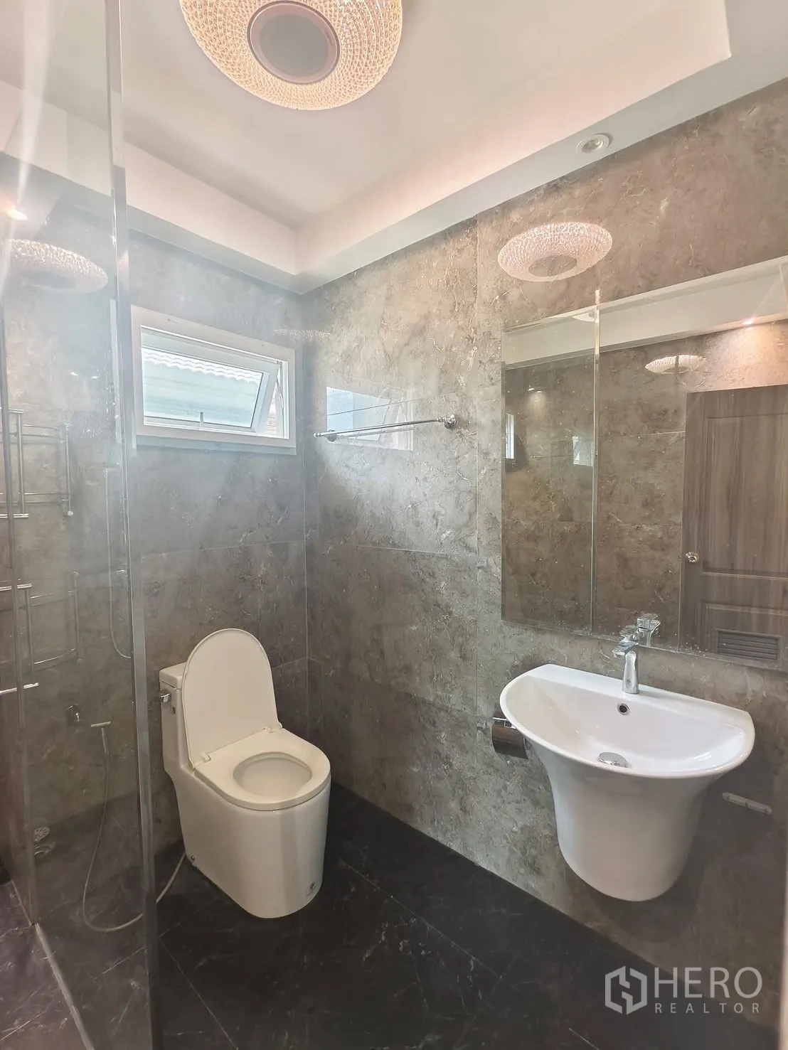 Detached House for rent in Bang Kapi, Bangkok - Contemporary bathroom with marble-look tiles, glass shower and vanity.