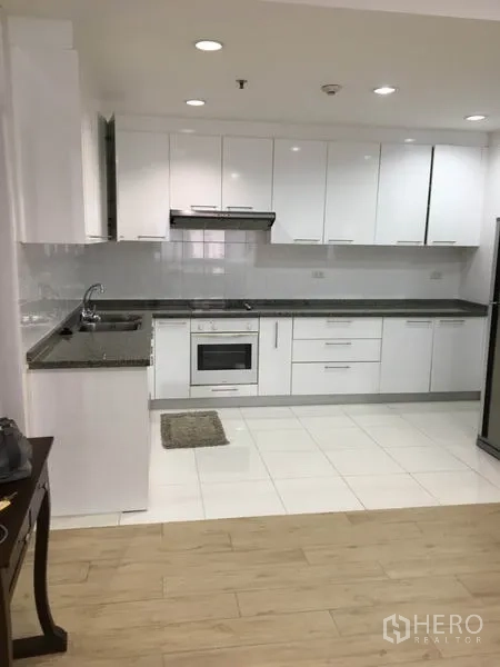 คอนโด ให้เช่าในWatthana, Bangkok - ครัวสไตล์โมเดิร์นหน้าบานสีขาว เคาน์เตอร์หินแกรนิต เตาอบ อ่างล้างจาน และตู้เย็นขนาดใหญ่
