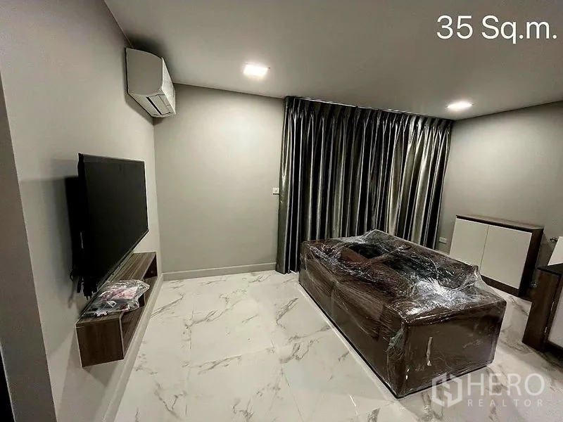 零售空间 出售在Khlong Toei, Bangkok - 起居空间，壁挂电视、包膜沙发与亮面地砖。