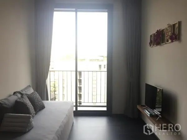 คอนโด ให้เช่าในWatthana, Bangkok - ห้องนั่งเล่นสว่าง โซฟา ทีวี และประตูกระจกบานเลื่อนออกสู่ระเบียง