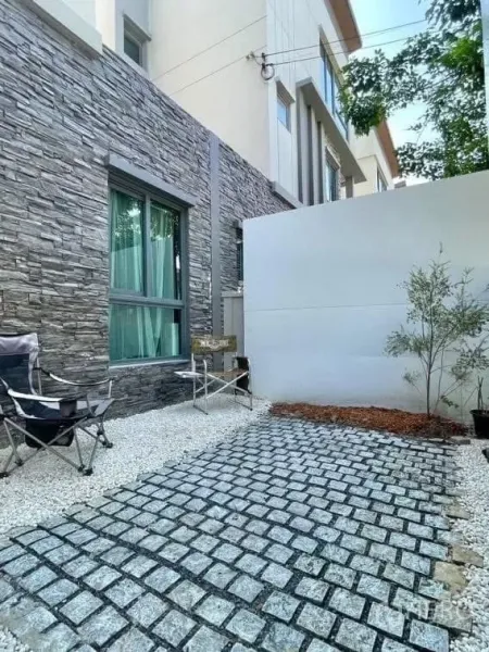 บ้าน ให้เช่าในSaphan Sung, Bangkok - ลานพักผ่อนส่วนตัว ผนังกรุหิน ทางเดินบล็อก พร้อมเก้าอี้สนาม.