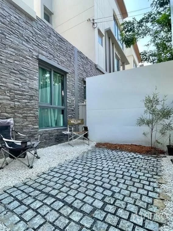 บ้าน ให้เช่าในSaphan Sung, Bangkok - ลานพักผ่อนส่วนตัว ผนังกรุหิน ทางเดินบล็อก พร้อมเก้าอี้สนาม.