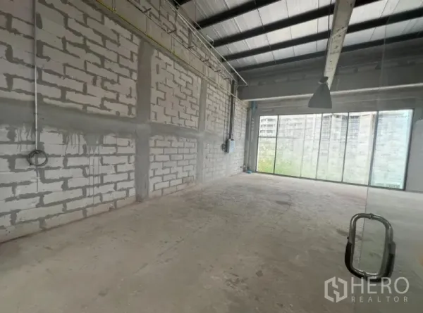 พื้นที่ขายปลีก ให้เช่า - ภายในโล่ง พื้นปูนเปลือย ผนังอิฐบล็อก เดินท่อเผย และกระจกเต็มผนังรับแสงธรรมชาติ