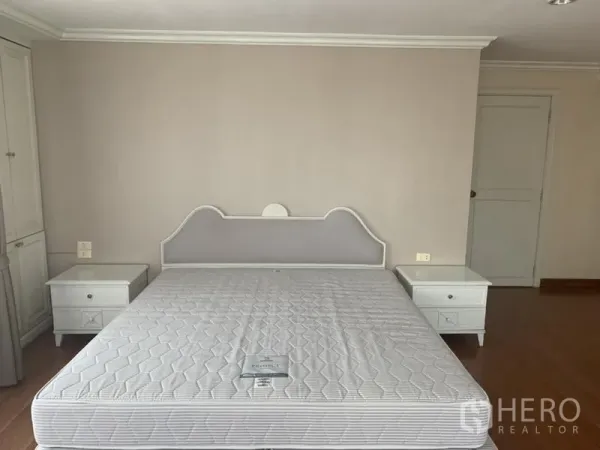 คอนโด ให้เช่าในWatthana, Bangkok - ห้องนอนหลักเตียงคิงส์พร้อมโต๊ะข้างเตียงคู่และผนสีโทนอบอุ่น