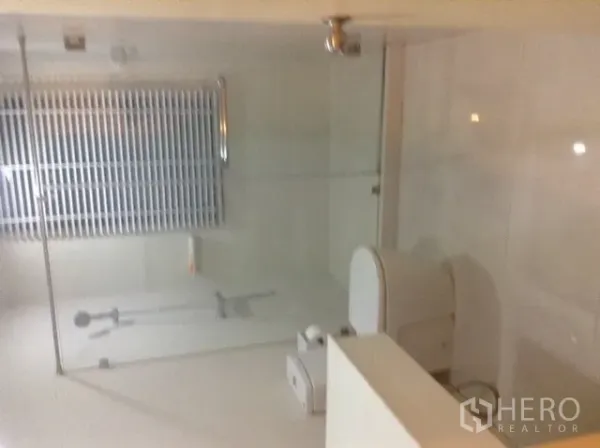 คอนโด ให้เช่าหรือขายในDin Daeng, Bangkok - ห้องน้ำอีกห้องพร้อมโถสุขภัณฑ์และส่วนอาบน้ำกระจกโทนสีเรียบ