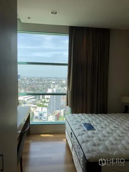 Condominium for rent in Bang Kho Laem, Bangkok - Bright bedroom with a large picture window and high-floor panoramic city view.