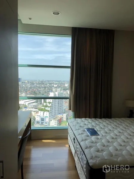 Condominium for rent in Bang Kho Laem, Bangkok - Bright bedroom with a large picture window and high-floor panoramic city view.