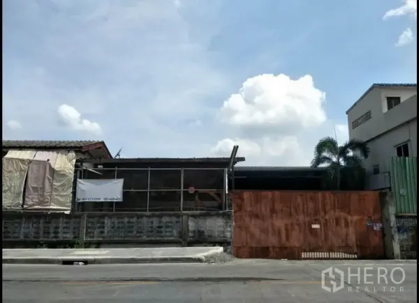 คลังสินค้า ขายในLat Krabang, Bangkok - ด้านหน้าทางเข้าโกดัง ประตูเหล็กสูงและกำแพงคอนกรีต ในย่านลาดกระบัง