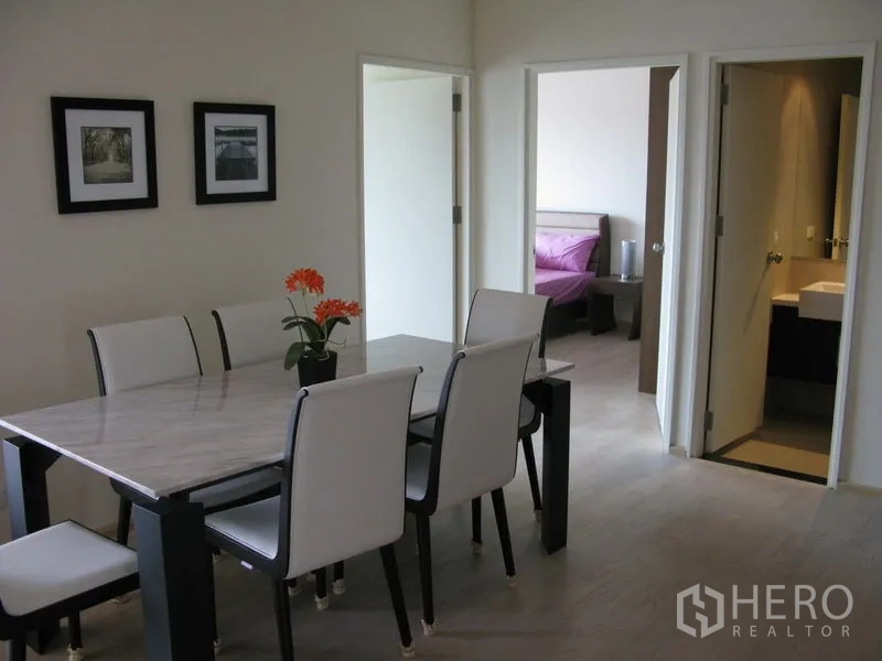 คอนโด ให้เช่าในKhlong Toei, Bangkok - มุมทานอาหารโต๊ะหินอ่อน เก้าอี้สีขาว ข้างประตูเข้าสู่ห้องนอนและห้องน้ำ