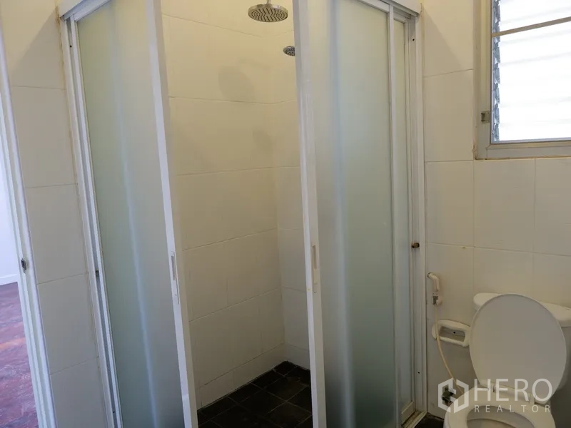 Detached House for rent in Khlong Toei, Bangkok - Bathroom with frosted-glass shower enclosures, rain shower and toilet.