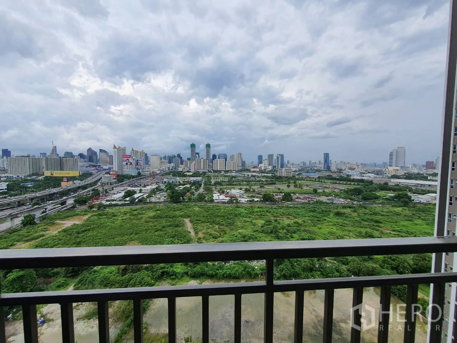 คอนโด for rent in Huai Khwang, Bangkok - วิวมุมสูงจากระเบียง เห็นสกายไลน์กรุงเทพฯ ทางด่วน และพื้นที่สีเขียว