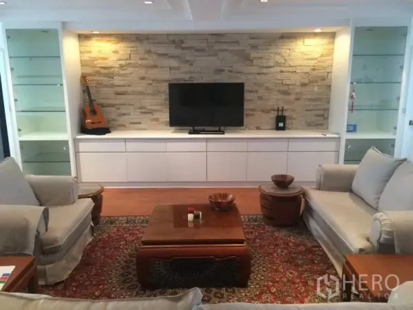 คอนโด ให้เช่าในKhlong Toei, Bangkok - ห้องนั่งเล่นกว้างของคอนโด President Park เขตคลองเตย ผนังหินตกแต่ง ตู้บิลท์อิน ทีวี โซฟา และโต๊ะไม้