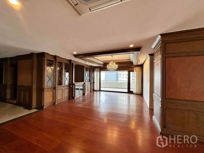 คอนโด ให้เช่าในBangkok - พื้นที่รับแขกโล่งโปร่งพร้อมโคมระย้าและประตูกระจกเปิดสู่ระเบียงกว้าง