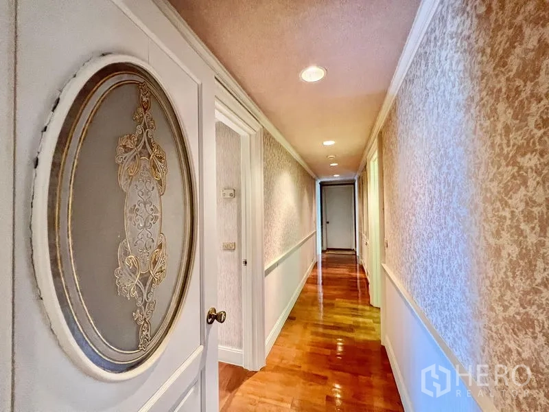 คอนโด ขายในPak Kret, Nonthaburi - โถงทางเดินยาว บานประตูตกแต่งลายวงรี คิ้วบัวผนัง และไฟฝังฝ้า