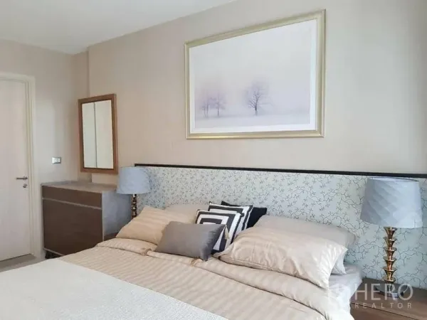 คอนโด ให้เช่าหรือขายในKhlong Toei, Bangkok - ห้องนอนบรรยากาศสงบ มีหัวเตียงบุผ้า โคมไฟหัวเตียง โต๊ะลิ้นชัก และภาพแขวนผนัง