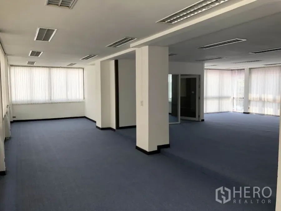 带办公室的家 出租在Huai Khwang, Bangkok - 超大开放式办公层，蓝色地毯、吊顶灯与结构柱。