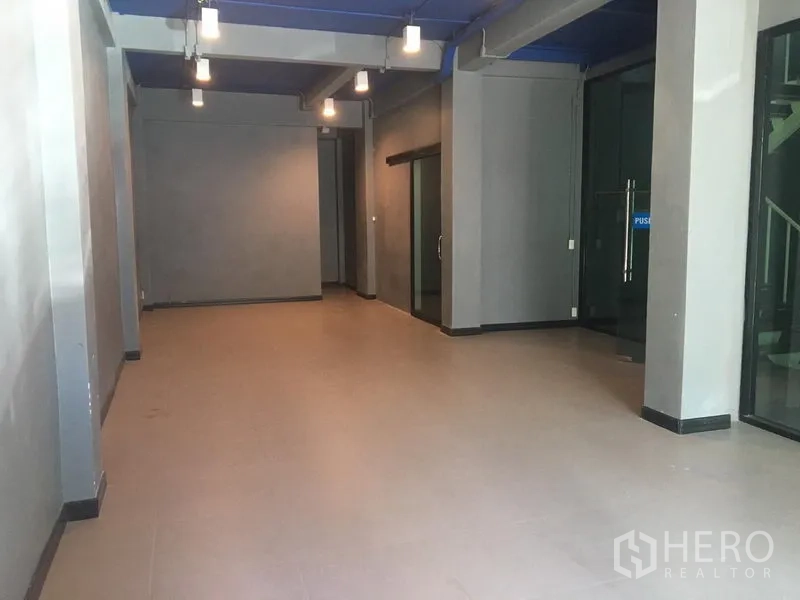 Retail Space for rent in Watthana, Bangkok - Empty ground-floor retail space with grey walls, blue ceiling and pendant lights.