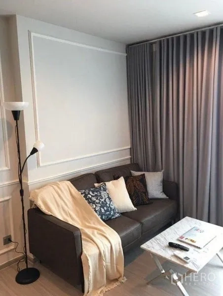 คอนโด ให้เช่าในRatchathewi, Bangkok - มุมโซฟาอบอุ่นพร้อมโคมไฟพื้นและผ้าม่านสองชั้น