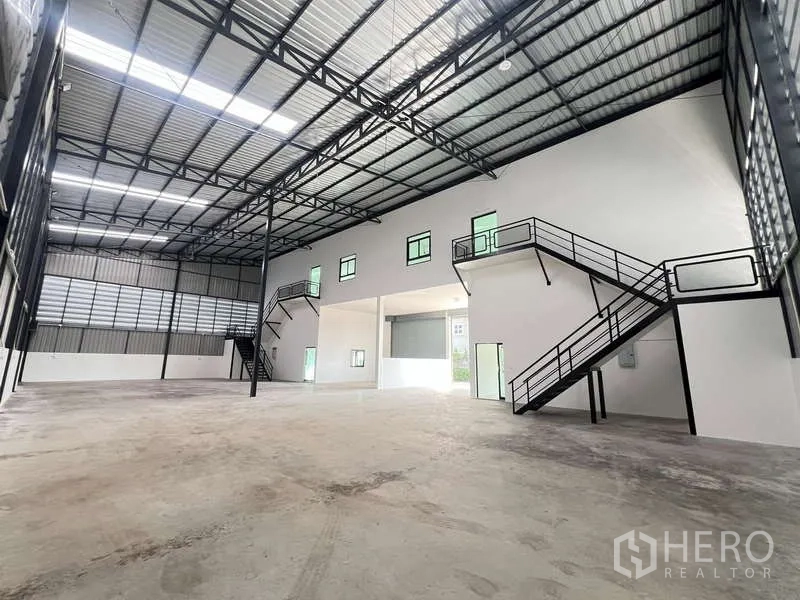 คลังสินค้า ให้เช่าหรือขาย - โกดังพื้นที่เปิดโล่งขนาดใหญ่ มีบันไดขึ้นเมซานีนสองฝั่ง และโครงหลังคาสูง