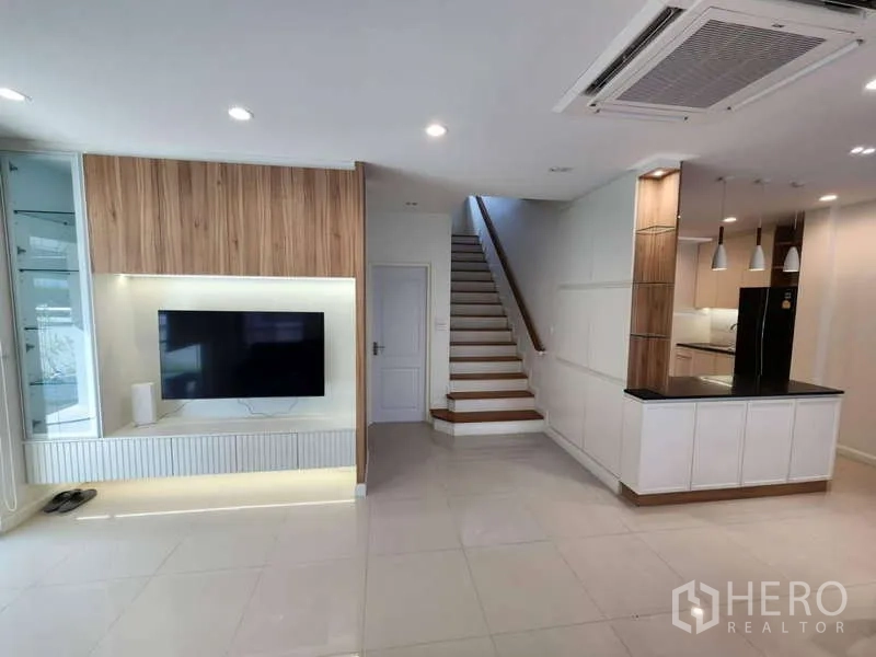 บ้าน ให้เช่าในSathon, Bangkok - ห้องนั่งเล่นสว่าง ผนังทีวี บันได และเคาน์เตอร์ครัว