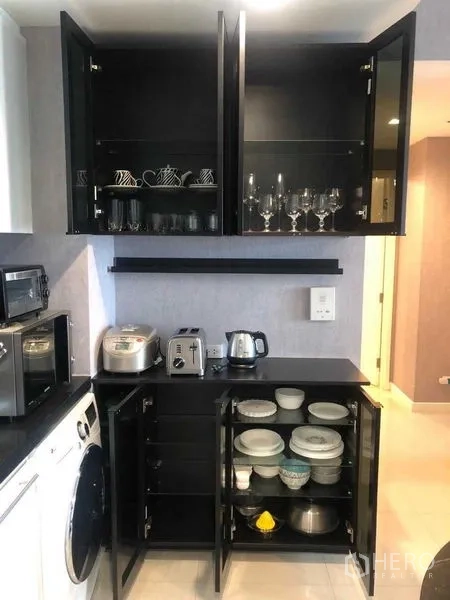 公寓 出租或出售在Bang Kho Laem, Bangkok - 厨房收纳柜打开展示餐具与小家电。