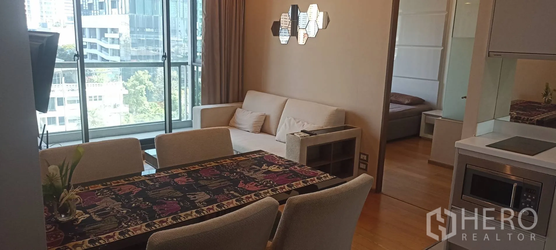Condominium for rent or sale in Bang Rak, Bangkok - Dining area facing the sofa with a bedroom entrance visible.
