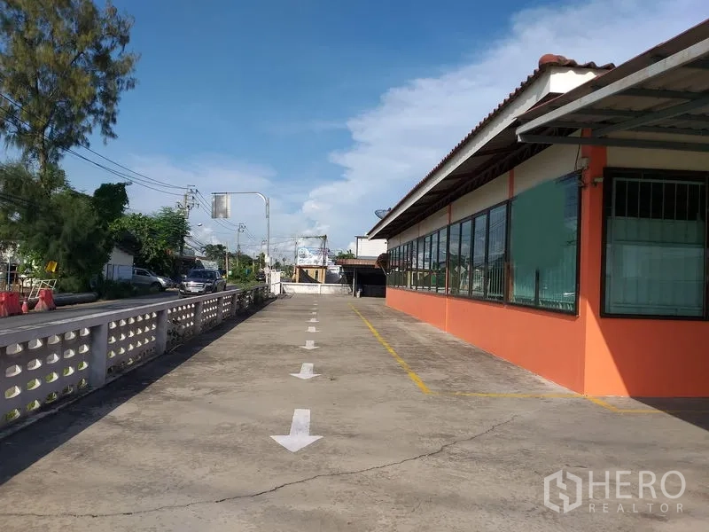 货栈 出租在Khlong Sam Wa, Bangkok - 仓库旁长车道，地面箭头与停车线清晰，靠近街道。