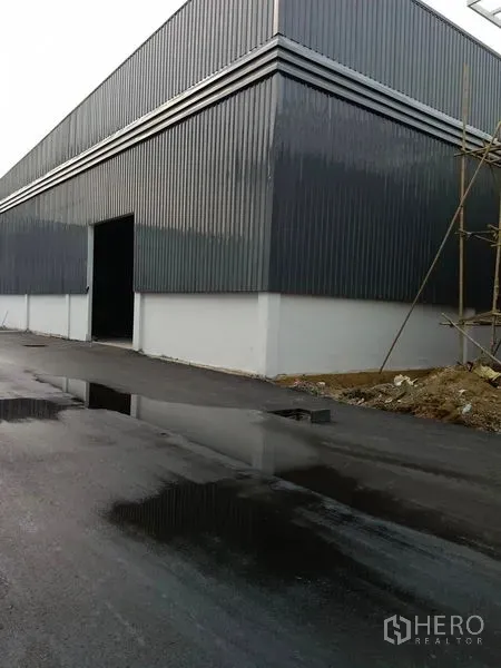 货栈 出租在Khlong Toei, Bangkok - 仓库转角处，开启的装货门与湿润的沥青道路