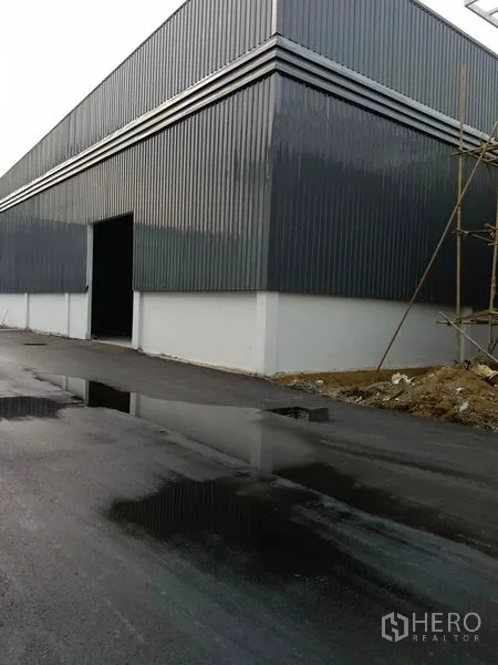 货栈 出租在Khlong Toei, Bangkok - 仓库转角处，开启的装货门与湿润的沥青道路