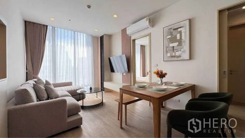 คอนโด ให้เช่าในWatthana, Bangkok - มุมกว้างห้องนั่งเล่น มีโต๊ะทานอาหาร ทีวีติดผนัง และเครื่องปรับอากาศ