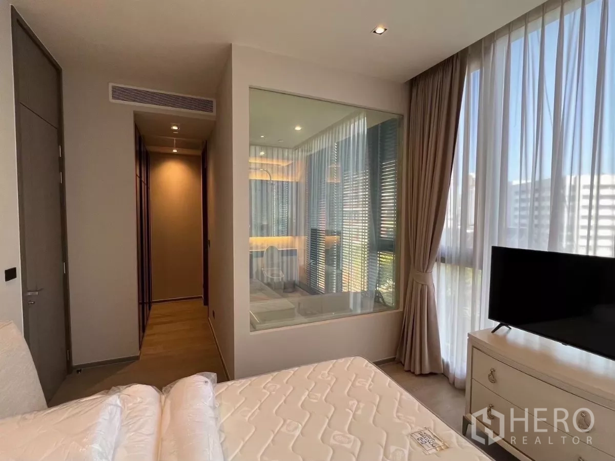 คอนโด ให้เช่าในWatthana, Bangkok - ห้องนอนมาสเตอร์มุมกระจก มีตู้วางทีวี และผนังกระจกเชื่อมห้องน้ำในตัว