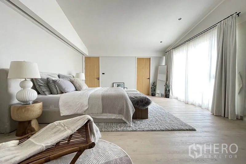 联排别墅 出售在Khlong Toei, Bangkok - 采光充足的卧室，整墙薄纱窗帘与浅木地板。