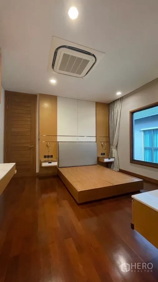 Detached House for rent in Prawet, Bangkok - Second bedroom featuring a platform bed, bedside pendants and wood floors.