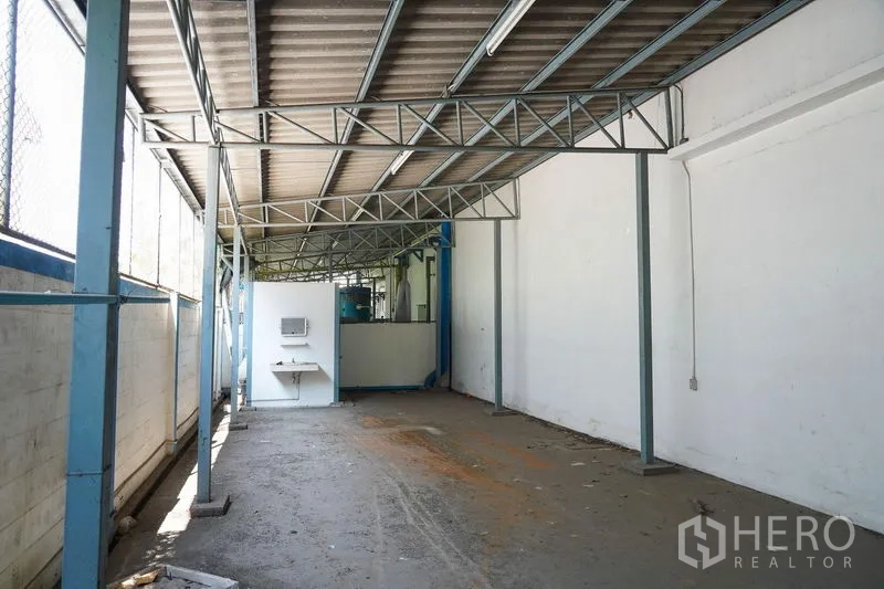 Factory for rent in Bang Sao Thong, Samut Prakan - Covered service area with steel canopy, concrete floor and wash basin.