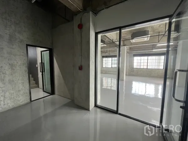 สำนักงาน ให้เช่าในKhlong Toei, Bangkok - โถงทางเข้าและประตูกระจกสู่พื้นที่สำนักงาน ผนังคอนกรีตเปลือย พร้อมบันไดภายใน