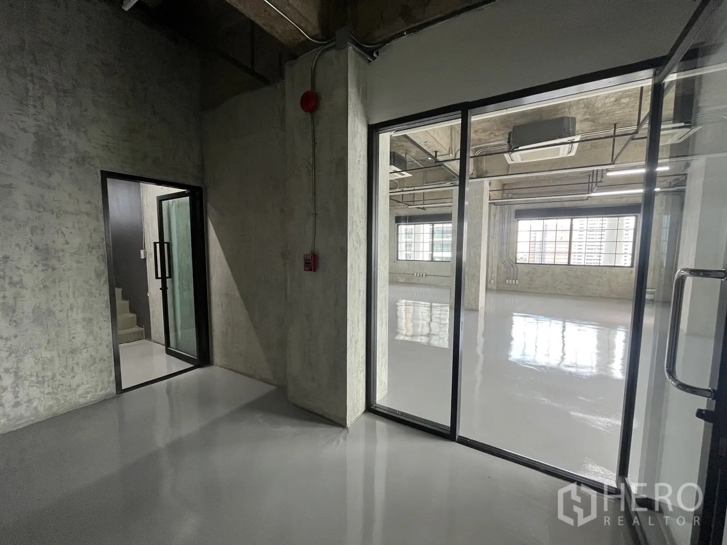 สำนักงาน ให้เช่าในKhlong Toei, Bangkok - โถงทางเข้าและประตูกระจกสู่พื้นที่สำนักงาน ผนังคอนกรีตเปลือย พร้อมบันไดภายใน