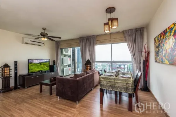 คอนโด ให้เช่าในBang Na, Bangkok - พื้นที่นั่งเล่นและทานอาหารสว่างโล่ง มีพัดลมเพดาน หน้าต่างบานใหญ่ และวิวเมือง