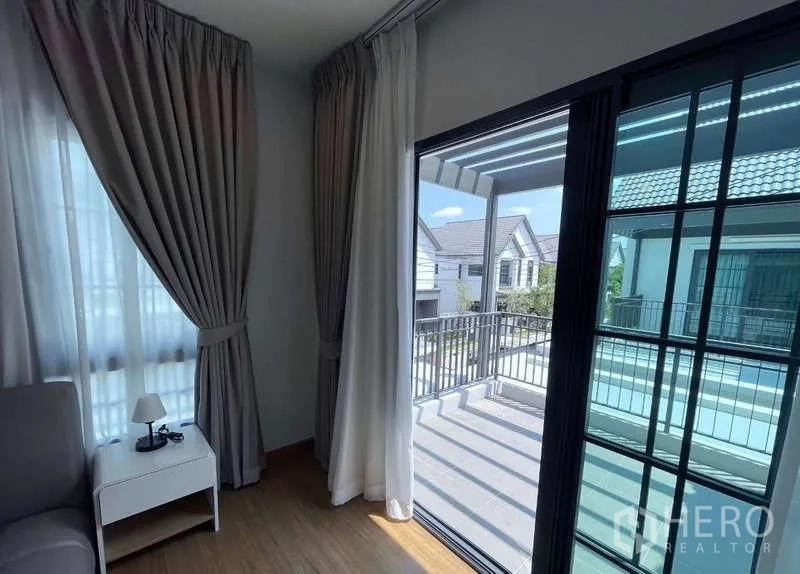 Detached House for rent in Bang Phli, Samut Prakan - Second-floor balcony access through sliding glass doors overlooking the neighborhood