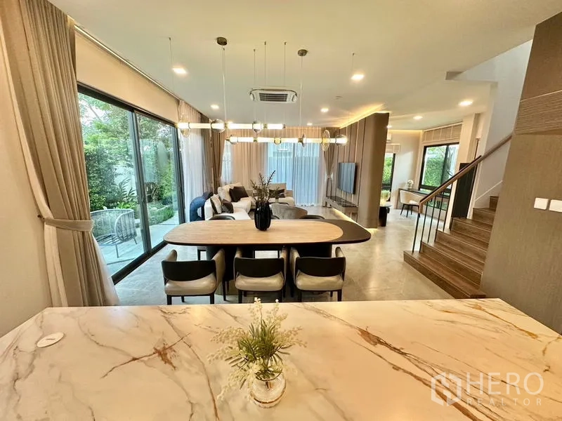 บ้าน ให้เช่าในSamut Prakan - มุมเกาะครัวมองไปยังส่วนทานอาหารและนั่งเล่น พร้อมโคมแขวน