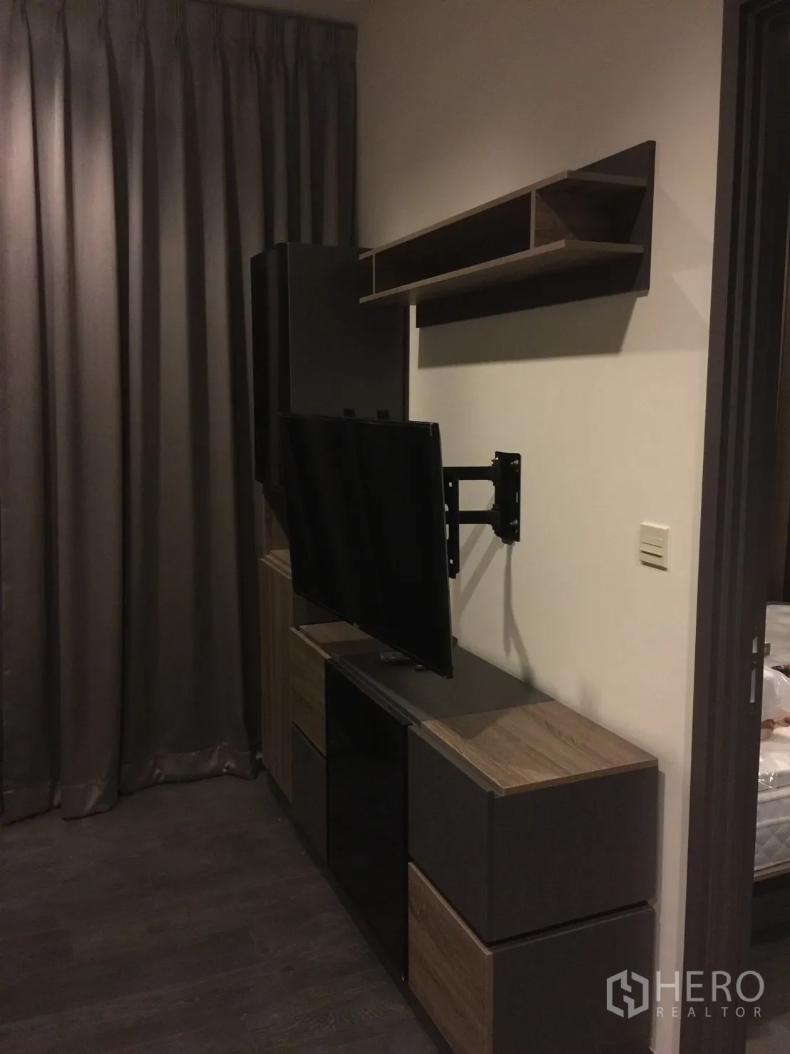 公寓 出租在Watthana, Bangkok - 起居区配壁挂电视支架、收纳电视柜与遮光窗帘。