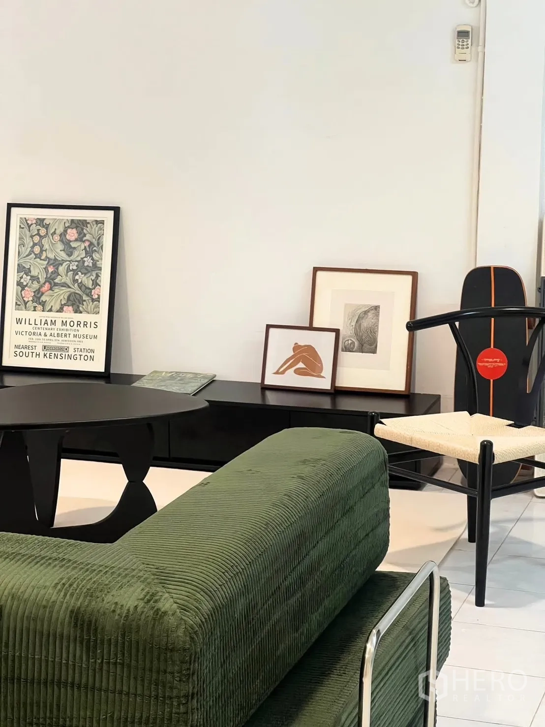 ทาวน์เฮาส์ ให้เช่า - มุมพักผ่อน โซฟาผ้าลอนสีเขียว ตู้วางทีวีสีดำ และเก้าอี้ดีไซน์