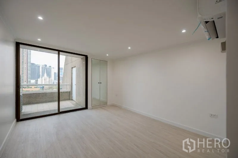 Condominium for sale - Bright bedroom with sliding doors to a balcony and glass closet.
