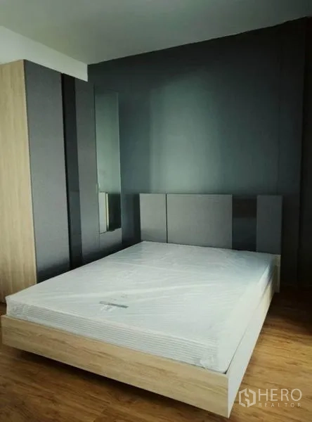 ทาวน์เฮาส์ ให้เช่าในSuan Luang, Bangkok - ห้องนอนผนังเทา ตู้เสื้อผ้าและเตียงควีน