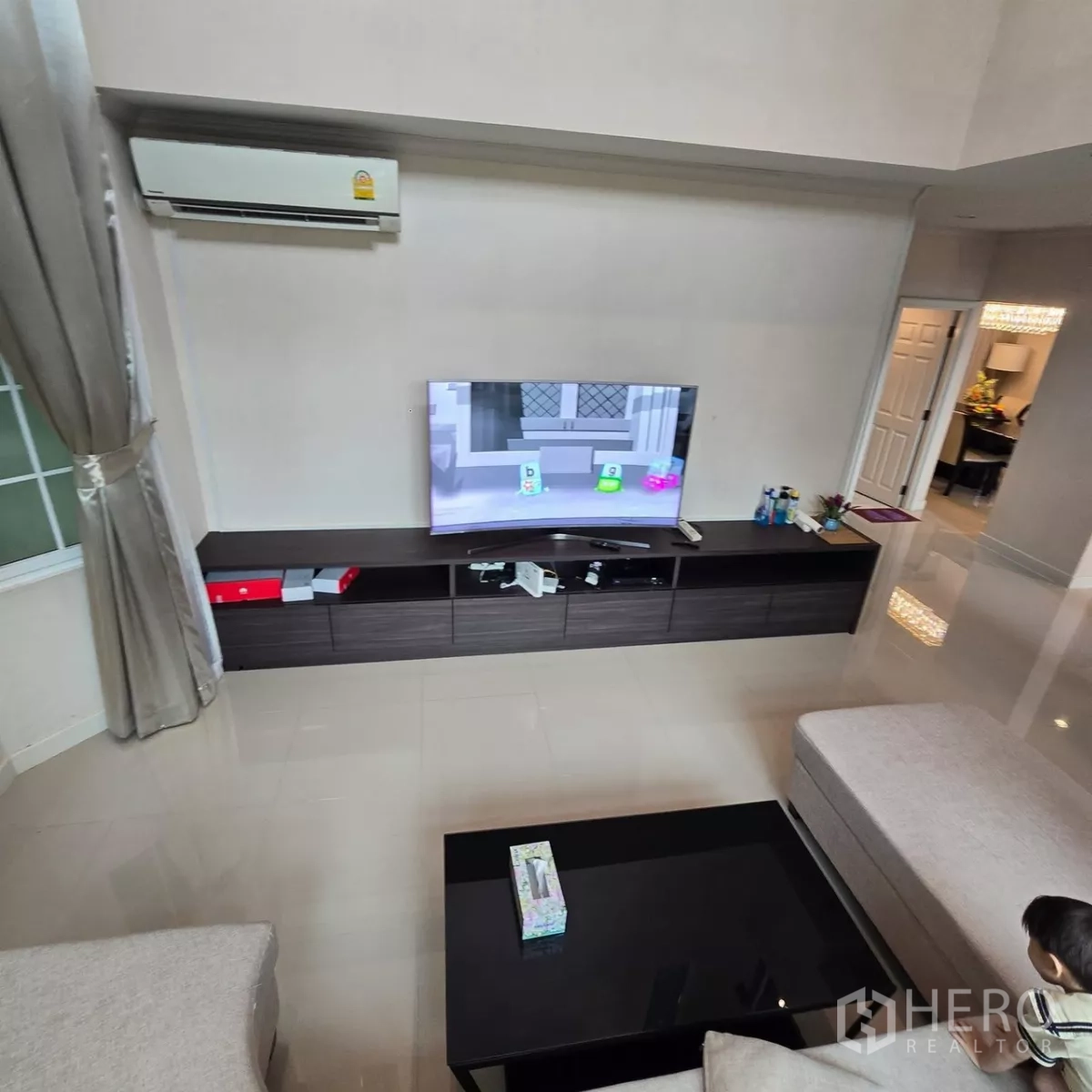 บ้าน ให้เช่าในMueang Pathum Thani, Pathum Thani - ผนังคอนโซลทีวีและเครื่องปรับอากาศในห้องนั่งเล่นทันสมัย