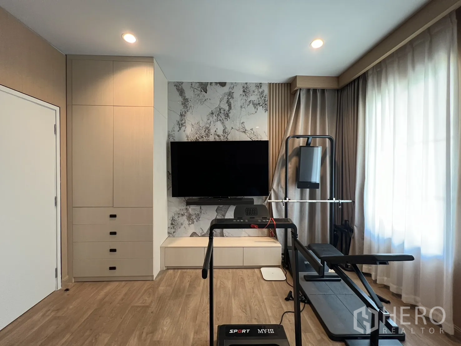 Detached House for rent or sale in Mueang Pathum Thani, Pathum Thani - Corner of fitness room with exercise machines and TV.