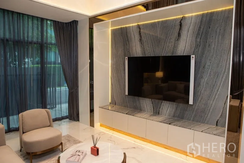 独立式住宅 出租或出售在Bangkok - 客厅电视背景墙为整块石材并配LED灯带。