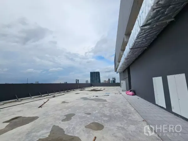 零售空间 出租 - 沿保温风管与设备面板的屋顶通道，可见城市建筑。